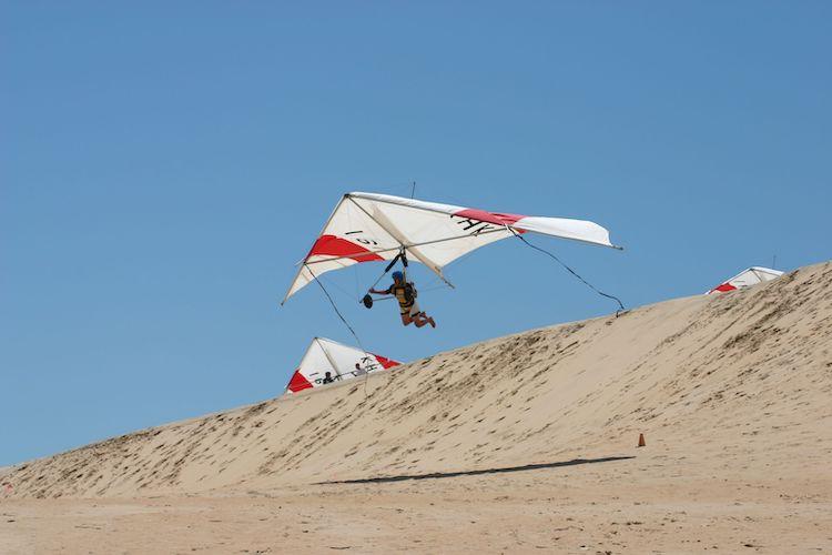 paraglider taking flight over a sand dune in nags head nc