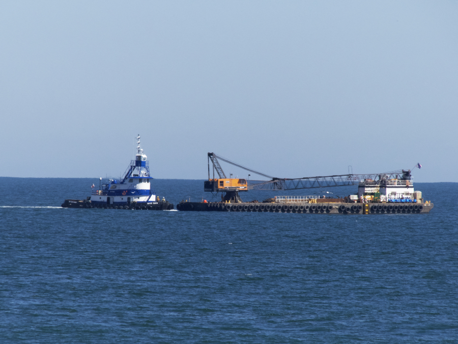 A barge is maneuvered into position to pump sand onto an Outer Banks Beach.